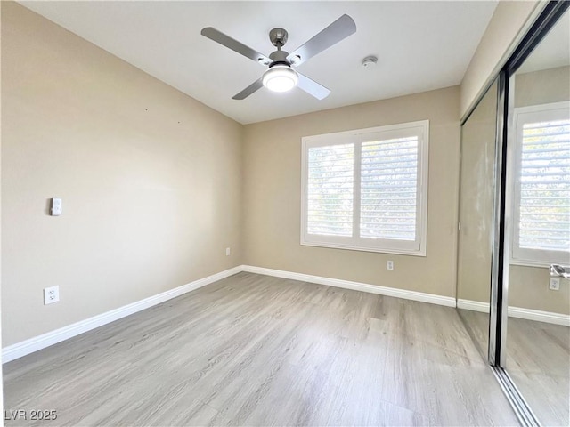 8070 W Russell Rd Unit 2070, Las Vegas, NV 89113 - unfurnished bedroom featuring baseboards, light wood-type flooring, multiple windows, and a closet