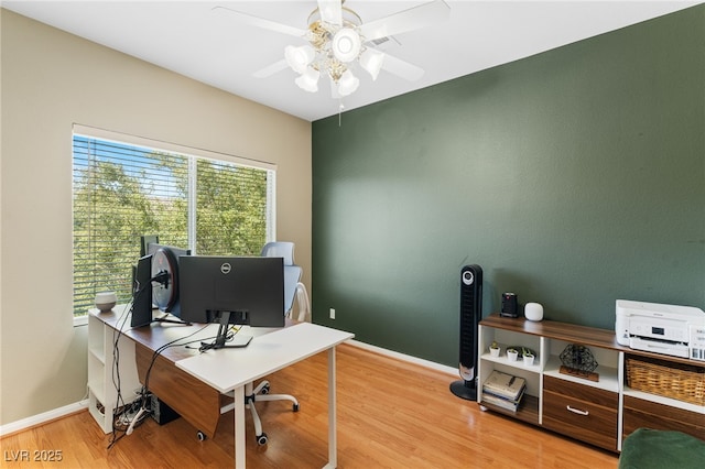 home office with baseboards, a ceiling fan, and light wood-style floors