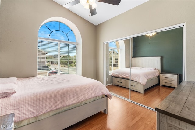 bedroom with a ceiling fan, light wood-style floors, and lofted ceiling