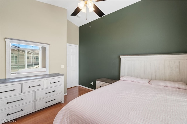 bedroom featuring a ceiling fan, high vaulted ceiling, dark wood finished floors, and baseboards