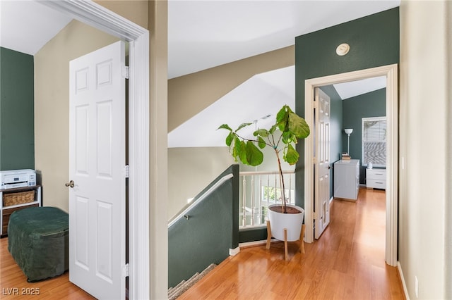 hall featuring an upstairs landing and wood finished floors