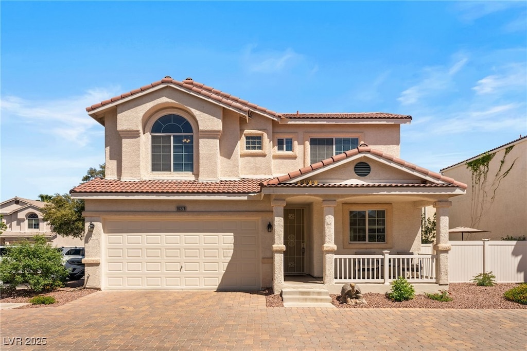 10276 Cherry Brook St, Las Vegas, NV 89183 - mediterranean / spanish-style house with a tile roof, decorative driveway, an attached garage, and covered porch