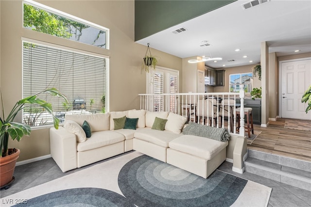 tiled living room with visible vents, recessed lighting, and baseboards
