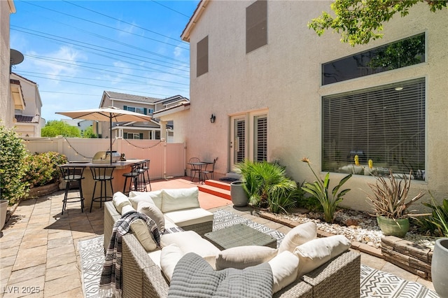 view of patio / terrace with an outdoor living space, fence, and outdoor dry bar