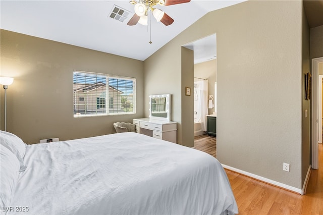 bedroom with lofted ceiling, visible vents, light wood-type flooring, and baseboards