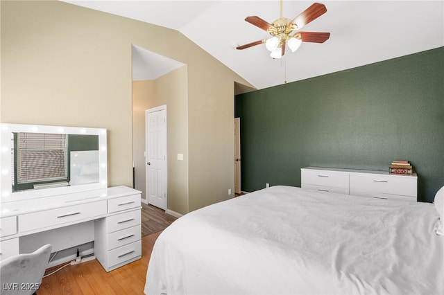 bedroom with lofted ceiling, light wood-style floors, and a ceiling fan