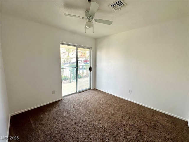empty room with carpet flooring, a ceiling fan, visible vents, and baseboards