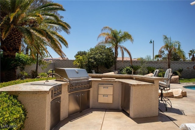 9905 Fox Springs Dr, Las Vegas, NV 89117 - view of patio / terrace featuring a fenced backyard, an outdoor kitchen, and a grill