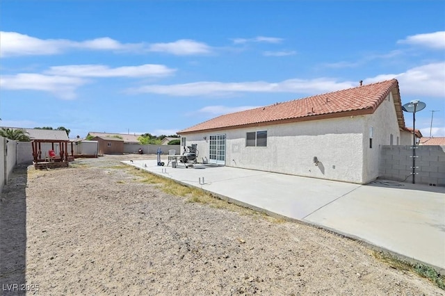 2805 El Cubano Ct, North Las Vegas, NV 89030 - rear view of house featuring a tiled roof, a storage shed, a fenced backyard, a patio, and stucco siding
