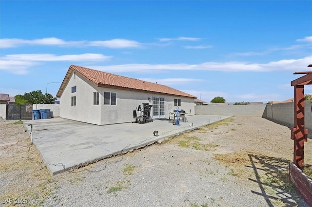 2805 El Cubano Ct, North Las Vegas, NV 89030 - back of property featuring a tiled roof, a fenced backyard, a patio area, and stucco siding