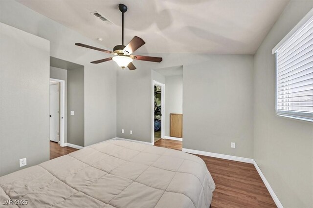 2805 El Cubano Ct, North Las Vegas, NV 89030 - bedroom with a walk in closet, a ceiling fan, visible vents, wood finished floors, and baseboards