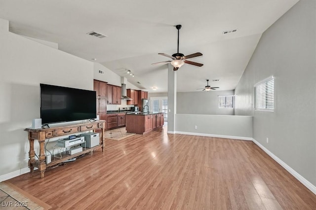 2805 El Cubano Ct, North Las Vegas, NV 89030 - living room featuring visible vents, light wood finished floors, ceiling fan, and vaulted ceiling