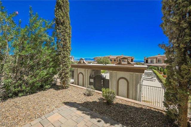 exterior space with a gate, fence, and stucco siding