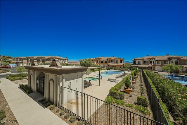 view of community with a residential view, a patio area, a swimming pool, and fence