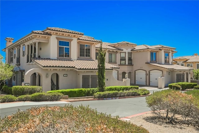 mediterranean / spanish-style home with driveway, a tiled roof, stucco siding, and a garage