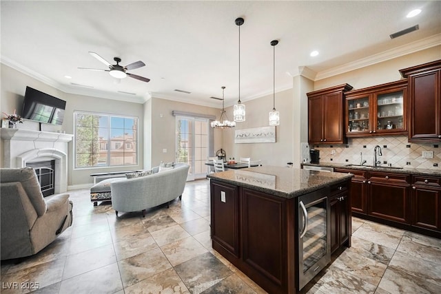 kitchen featuring open floor plan, wine cooler, ceiling fan with notable chandelier, and a sink