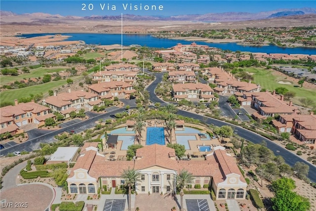 drone / aerial view with golf course view, a residential view, and a water and mountain view