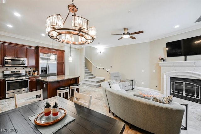 living area featuring ornamental molding, recessed lighting, stairway, and ceiling fan with notable chandelier