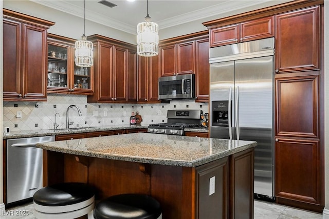 kitchen featuring light stone countertops, a sink, glass insert cabinets, a center island, and appliances with stainless steel finishes
