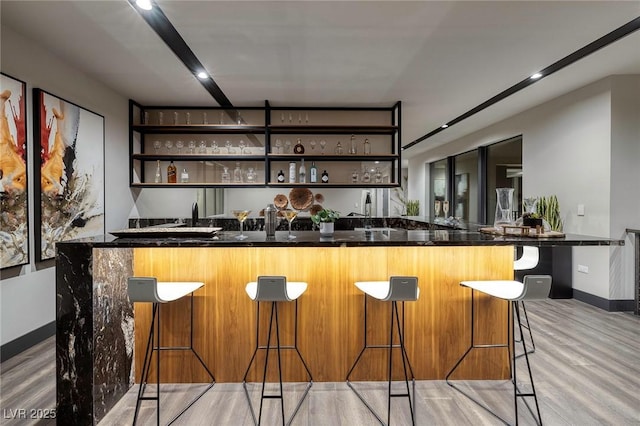 811 Magnum Cliff Ct, Henderson, NV 89012 - bar with light wood-style floors, indoor wet bar, and baseboards