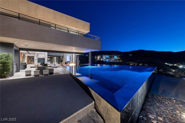 811 Magnum Cliff Ct, Henderson, NV 89012 - pool at night with a patio area, an outdoor living space, and an infinity pool