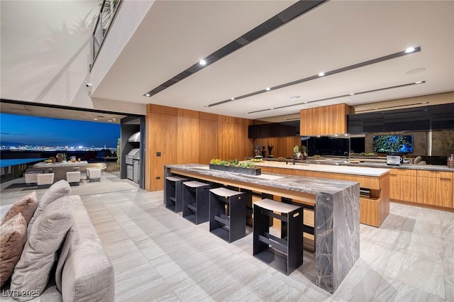 811 Magnum Cliff Ct, Henderson, NV 89012 - kitchen featuring a center island, brown cabinets, open floor plan, modern cabinets, and light countertops