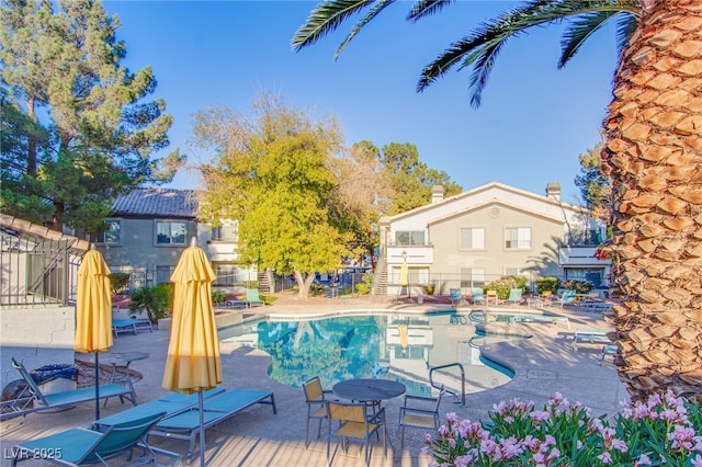 pool featuring fence and a patio area