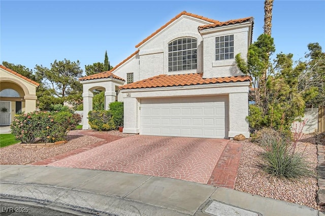 9921 Heffner Hills Cir, Las Vegas, NV 89117 - mediterranean / spanish home featuring a garage, stucco siding, decorative driveway, and a tile roof