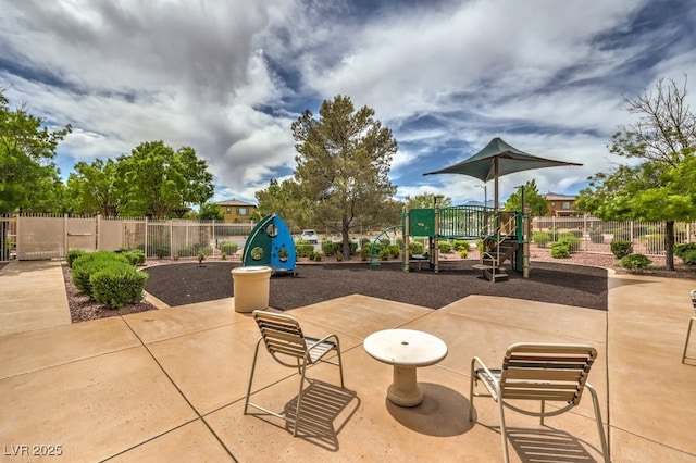 view of patio / terrace featuring playground community and fence