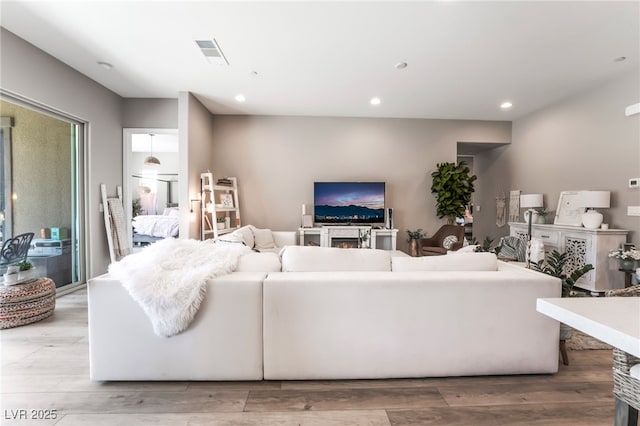 living area with visible vents, wood finished floors, and recessed lighting