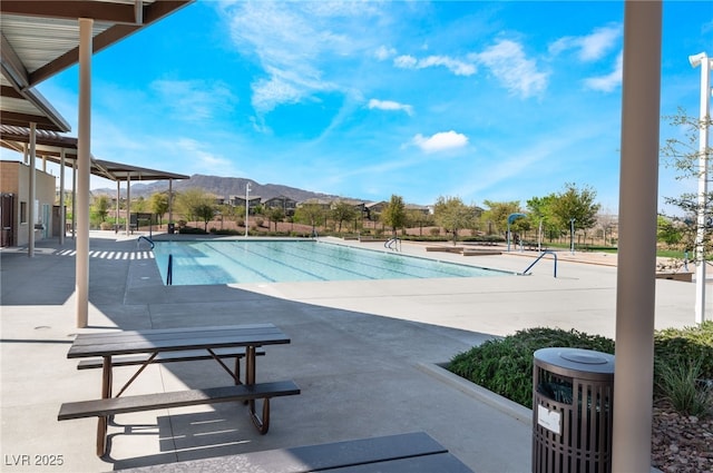 community pool with a patio and a mountain view