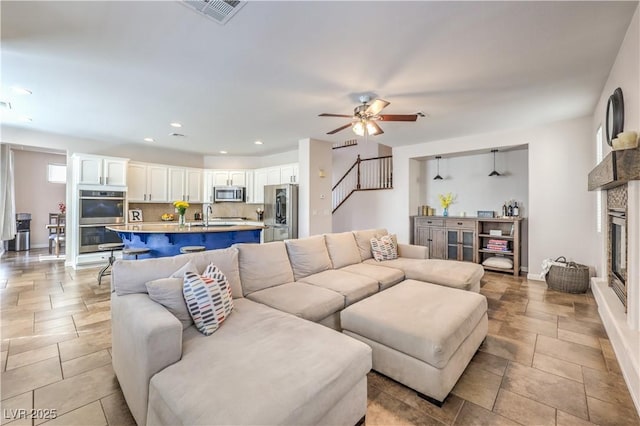 living room featuring recessed lighting, a fireplace, ceiling fan, visible vents, and baseboards
