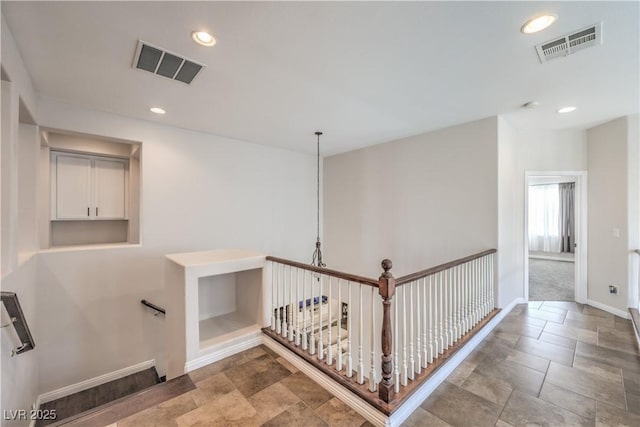 corridor featuring stone finish floor, visible vents, recessed lighting, and baseboards