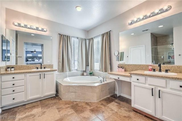 bathroom with visible vents, a shower stall, a bath, and a sink