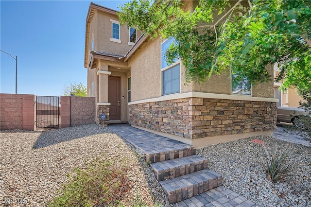4902 Guysborough St, Las Vegas, NV 89148 - view of front facade featuring stucco siding, a gate, and stone siding