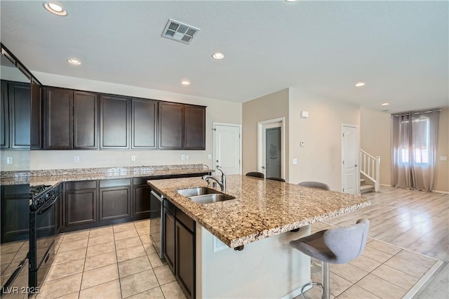 4902 Guysborough St, Las Vegas, NV 89148 - kitchen featuring a sink, black gas range oven, stainless steel dishwasher, recessed lighting, and light stone countertops