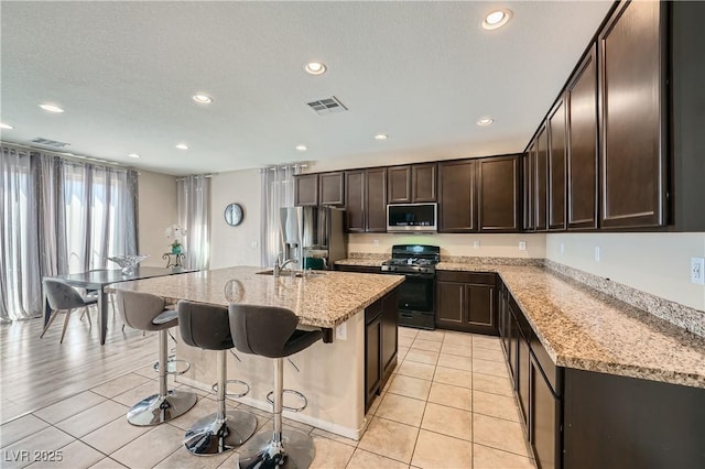 4902 Guysborough St, Las Vegas, NV 89148 - kitchen featuring appliances with stainless steel finishes, a sink, dark brown cabinets, recessed lighting, and a breakfast bar area