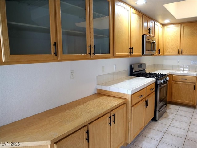6508 Alpine Forest Ct, Las Vegas, NV 89149 - kitchen featuring appliances with stainless steel finishes, glass insert cabinets, recessed lighting, and light tile patterned floors