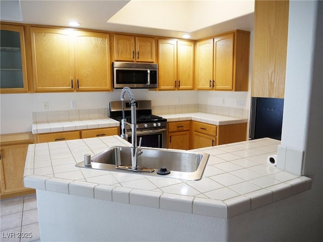 6508 Alpine Forest Ct, Las Vegas, NV 89149 - kitchen featuring stainless steel appliances, glass insert cabinets, light tile patterned flooring, a sink, and tile counters
