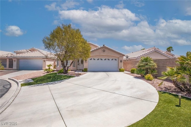 view of front facade featuring stucco siding, a tiled roof, concrete driveway, an attached garage, and fence