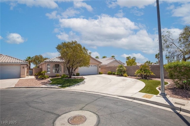 view of front of property with stucco siding, a tiled roof, fence, driveway, and an attached garage