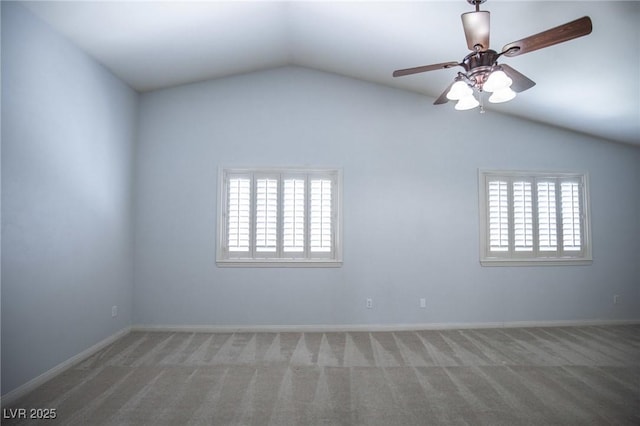 carpeted empty room featuring baseboards, ceiling fan, and lofted ceiling