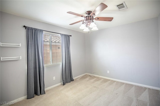 carpeted spare room featuring visible vents, ceiling fan, and baseboards