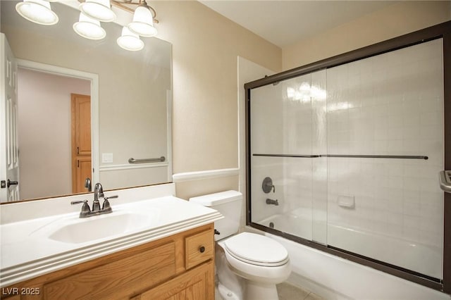 full bathroom with combined bath / shower with glass door, vanity, and toilet