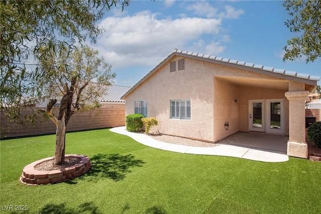 back of house featuring a lawn, stucco siding, french doors, and fence