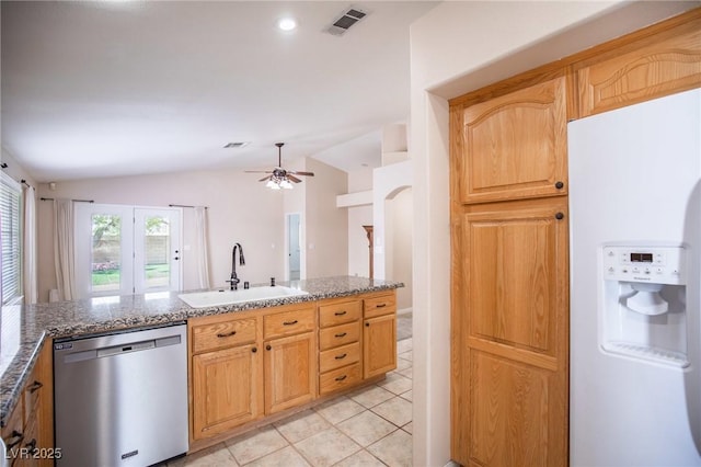 kitchen with white fridge with ice dispenser, stainless steel dishwasher, a sink, visible vents, and vaulted ceiling