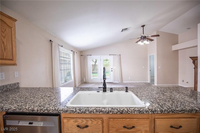 kitchen with vaulted ceiling, dark countertops, dishwasher, a sink, and visible vents