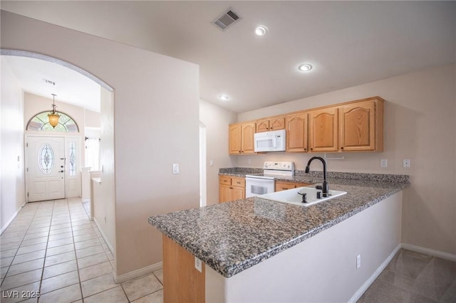 kitchen with baseboards, visible vents, white appliances, and a sink