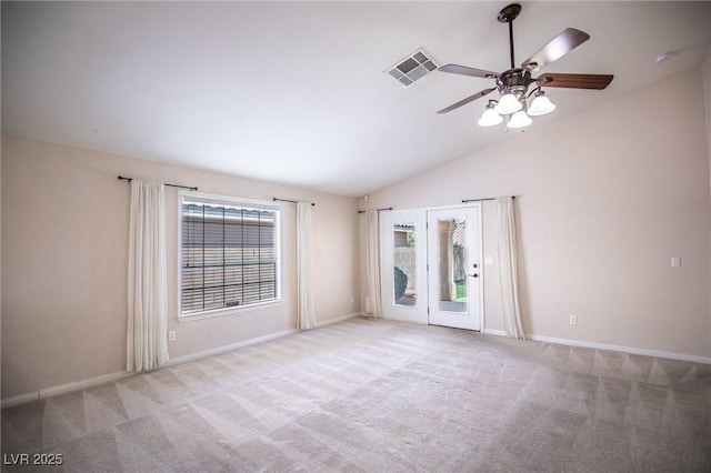 carpeted empty room with baseboards, visible vents, a ceiling fan, and vaulted ceiling
