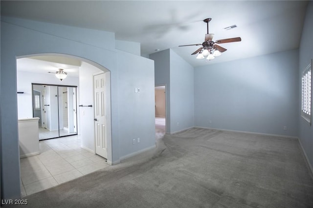 empty room with arched walkways, ceiling fan, carpet floors, and baseboards